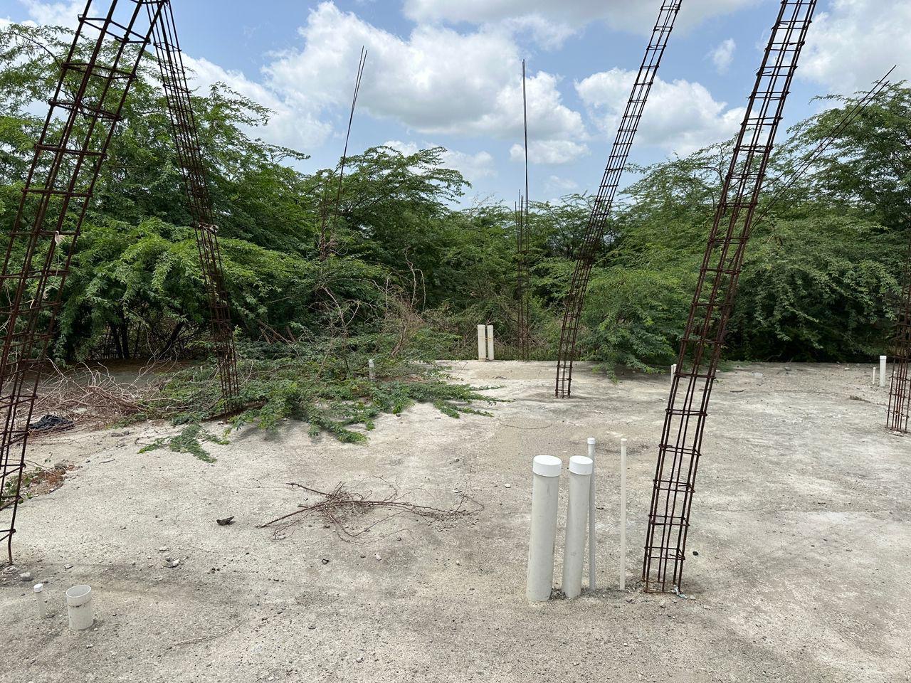 Rebar columns and roughed-in plumbing standing on a poured slab